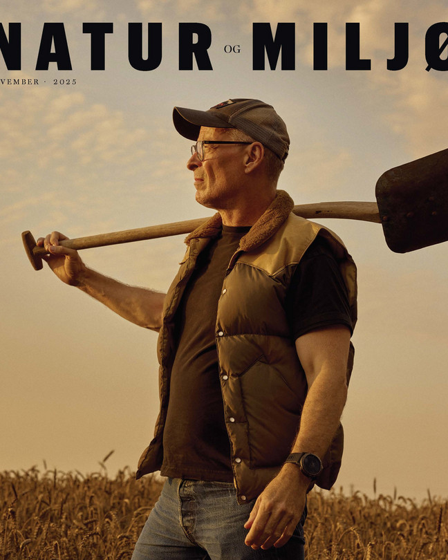 Eske Willerslev on the cover of Nature and Environment, standing in a barley field with a shovel on his shoulder.