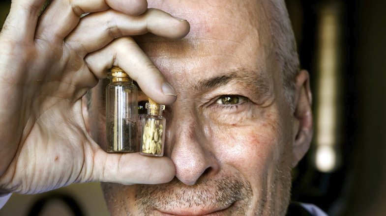 Frontpage of Dagens ETC showing Eske Willerslev holding two small jars of seeds in front of his eyes.